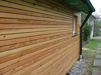 Dřevěná fasáda s horizontálně položenými prkny na domě.