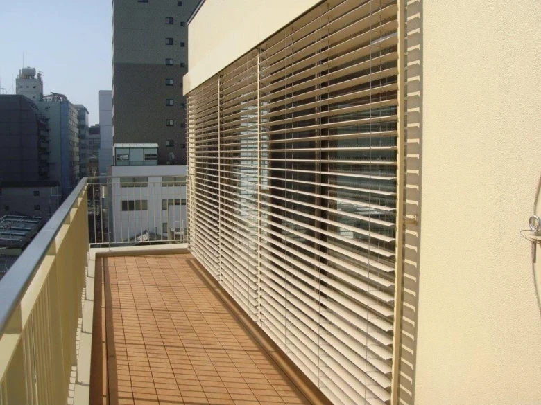 Venkovní žaluzie na balkóně v městském prostředí.