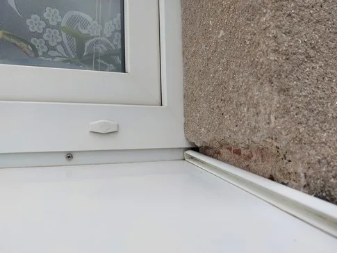 Detailní pohled na montáž venkovního parapetu u okna.
