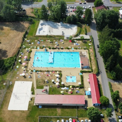 Vzduchem pořízený pohled na venkovní bazén v Sušici s více plaveckými bassény.