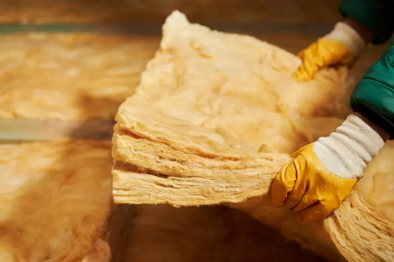 Pracovník manipulující s tepelně izolačním materiálem ve výrobě.