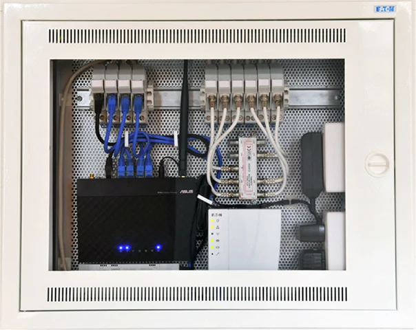 Vnitřní sestava elektrického rozvaděče s připojeným síťovým zařízením.