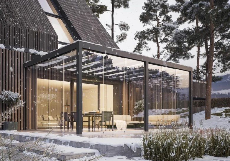 Skleněná pergola připojená k domu v zimním prostředí.