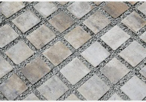 Betonové zatravňovací dlaždice s kamenným záplatem pro propustnost vody.