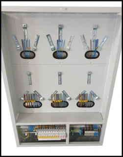 Vnitřní část elektrického rozvaděče s jističi a svorkovnicemi.