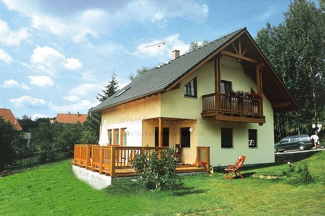 Dřevostavba v Rýmařově s dřevěným balkonem na trávníku.