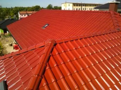 Červená tašková střecha s výraznou konstrukcí a okapovými prvky.