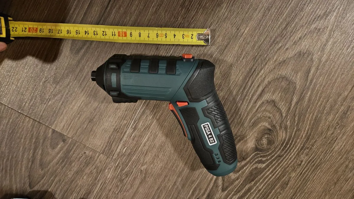 Bezdrátová vrtačka s páskou na dřevěném podlaze pro stavební práce.