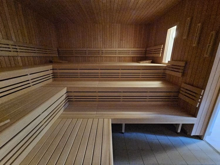 Vnitřek sauny s dřevěnými lavicemi v bazénu nebo aquaparku.