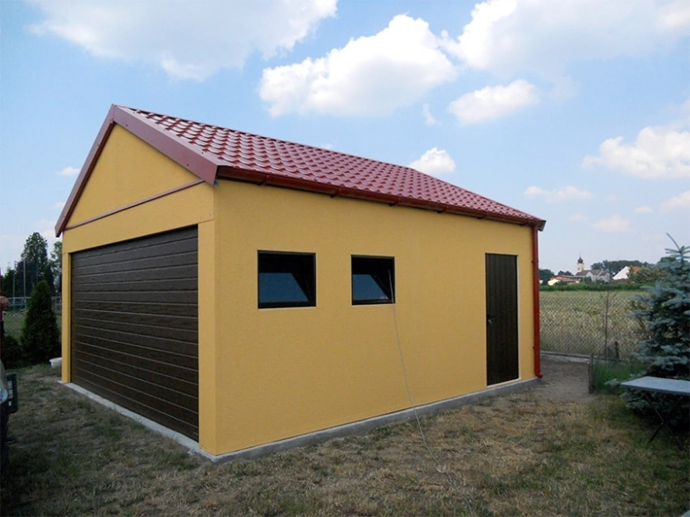 Žlutá montovaná garáž s omítkou a červenou střechou.