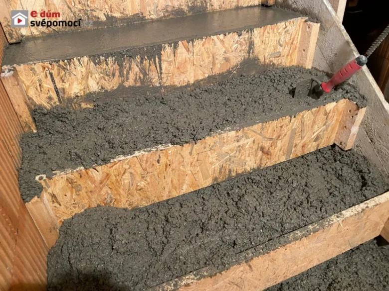Zálivka betonu do dřevěných forem pro stavbu schodiště.