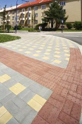 Různé typy betonové dlažby s taktickými prvky pro chodníky.