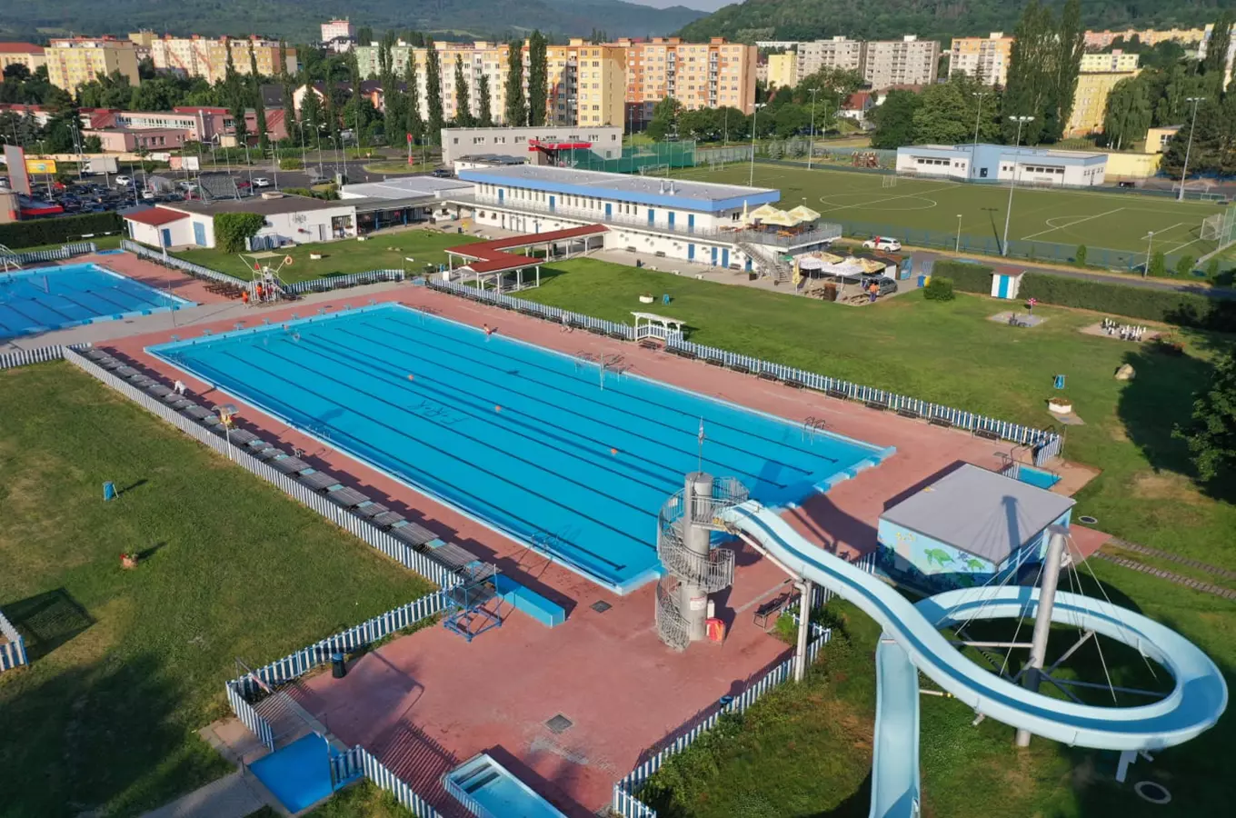 Vzdušný pohled na venkovní plavecký bazén s vodním skluzavkou v Kadani.