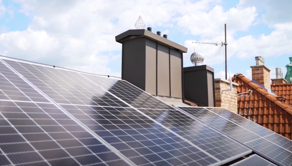 Fotovoltaické panely na střeše rodinného domu pod oblohou.