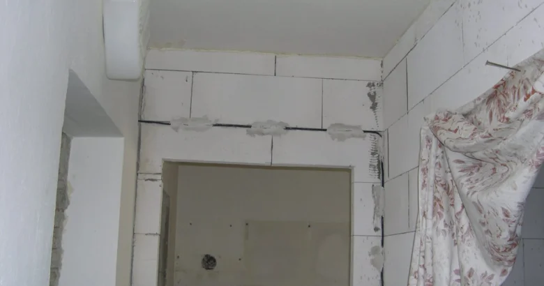 Koupelna v rekonstrukci s novými bloky na stěnách.