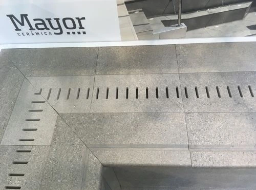 Šedá dlažba kolem bazénu s lineárním odvodňovacím systémem.