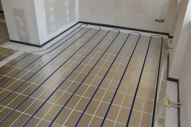 Modré potrubí podlahového topení na suché podlaze v místnosti.