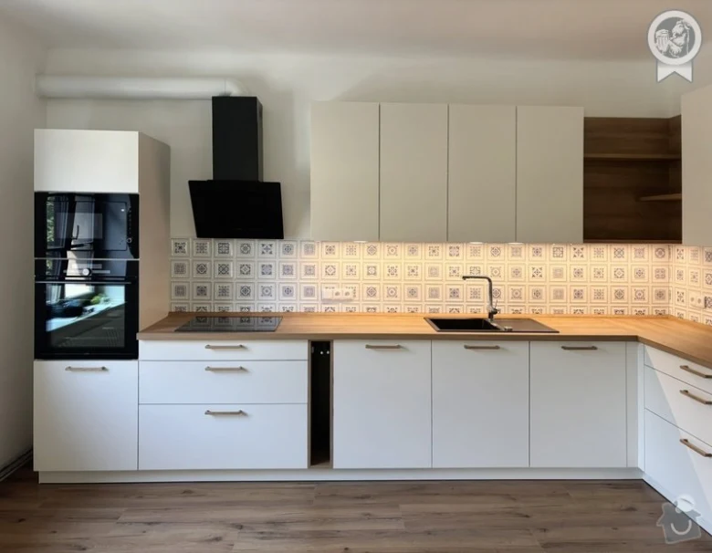 Moderní bílá kuchyně na míru s dřevěnými pracovními deskami.