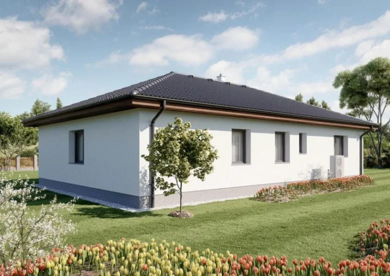 Moderní bílý bungalov s tmavou střechou na zelené trávě.