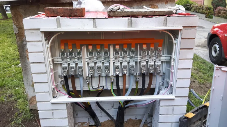 Otevřená elektrická skříň s barevně označenými kabely v instalaci.