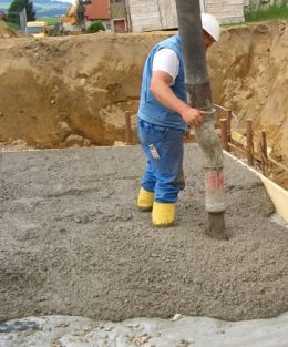 Stavebník míchá beton z pytli přímo na staveništi.