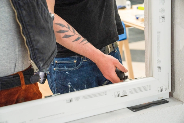 Instalace bílého okenníku s použitím nástrojů v interiéru