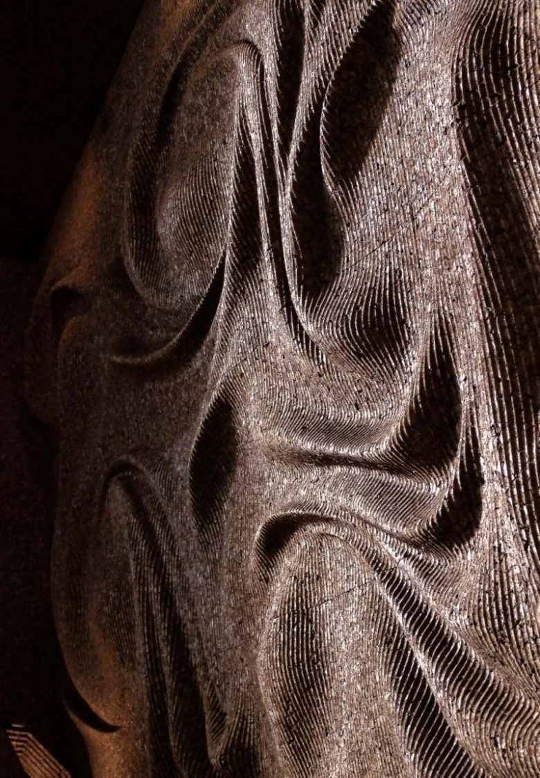 Detail dřevěného obložení stěn s vyřezaným vzorem.