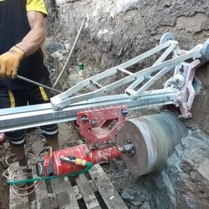 Pracovník používá jádrovák k vrtání vzorku z betonu.