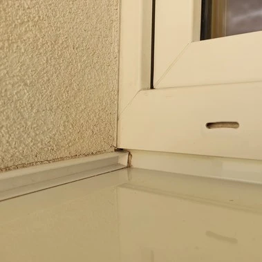 Detailní pohled na spojení okenního rámu s podlahou pro montáž venkovního parapetu.