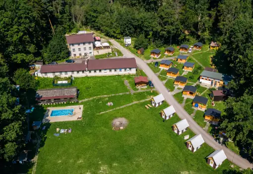 Pohled na kemp s chatami bazénem v lese