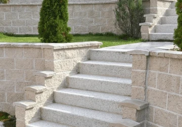 Venkovní betonové schody vedoucí na trávník.