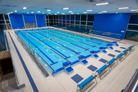 Fotografie vnitřního plaveckého bazénu s dráhami pro závodění.