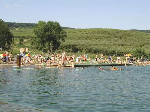 Lidé plavou v přírodním koupališti na jižní Moravě.
