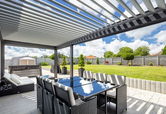 Moderní hliníková pergola s venkovním jídelním setem na zahradě.